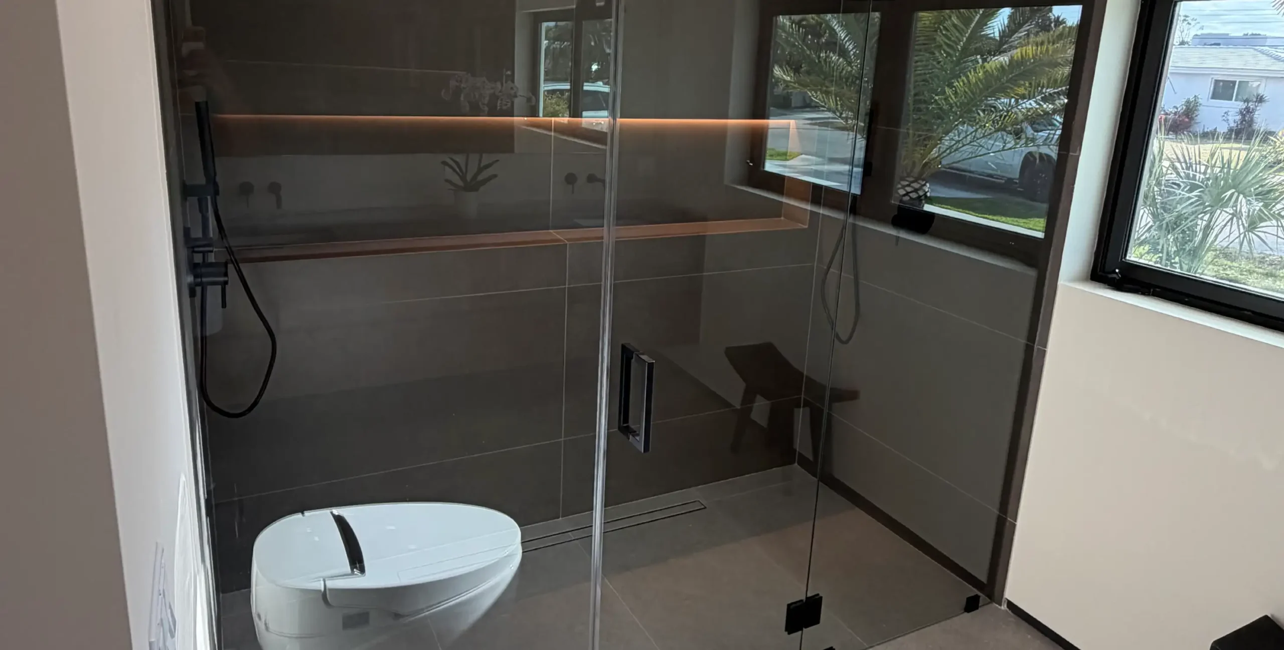 Modern bathroom remodel featuring a custom glass walk-in shower by Delaurentiis Construction in Fort Lauderdale, FL.