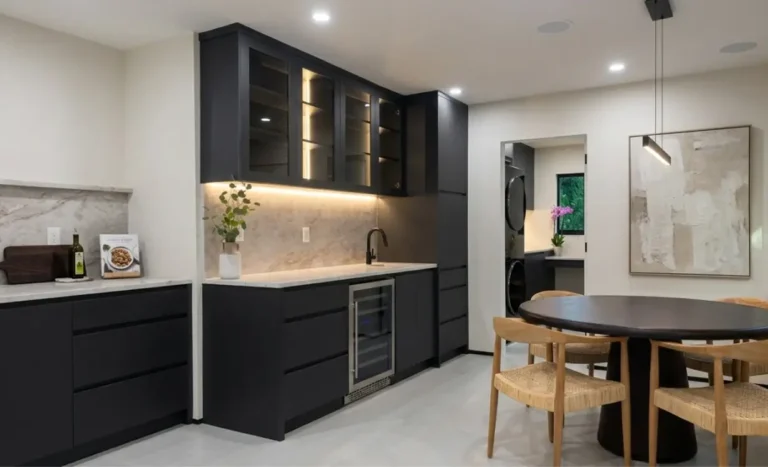 Luxury kitchen remodeling featuring a custom dark bar area and wine cooler by Delaurentiis Construction.